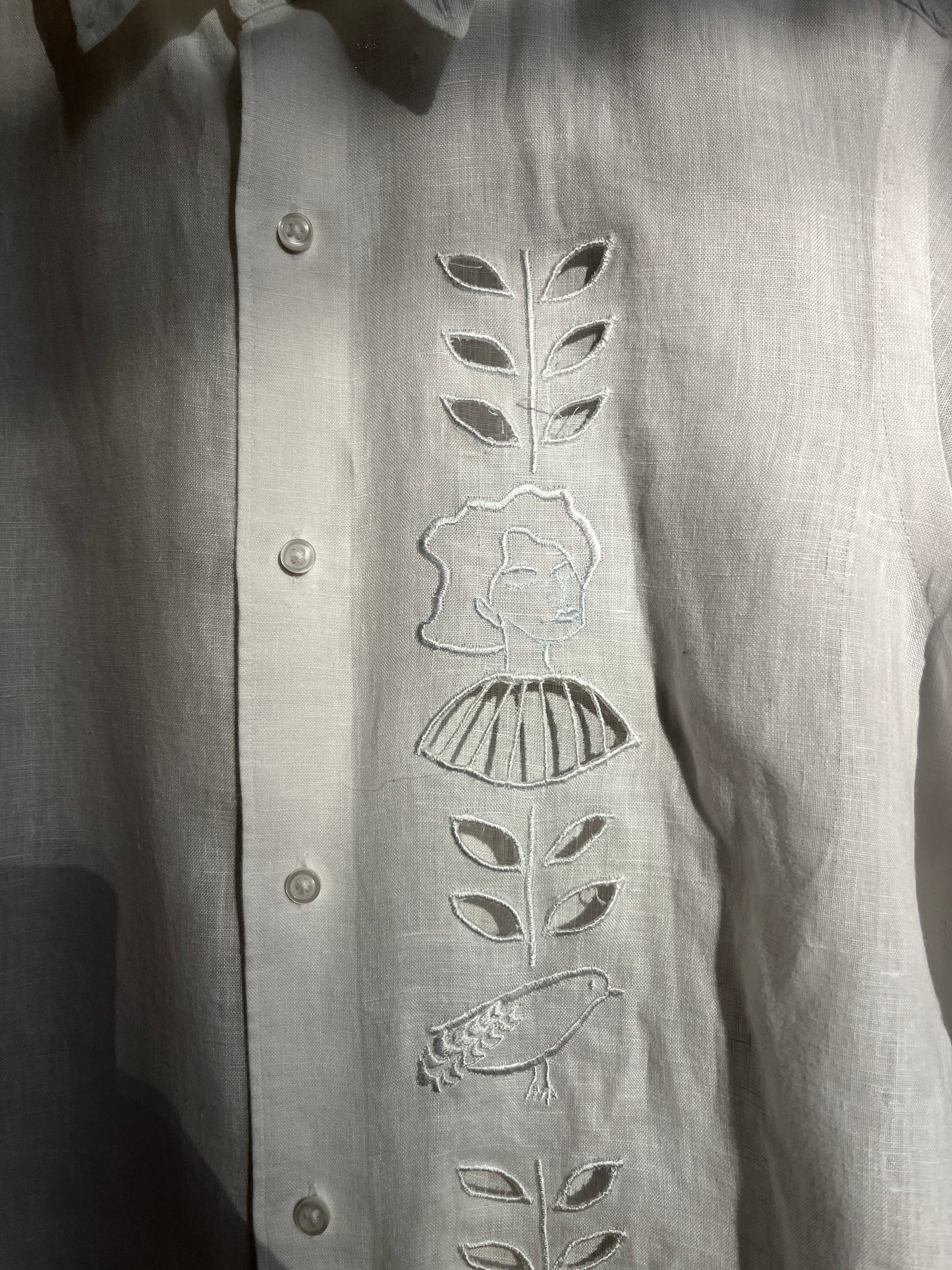 Cut work embroidery on a white linen shirt